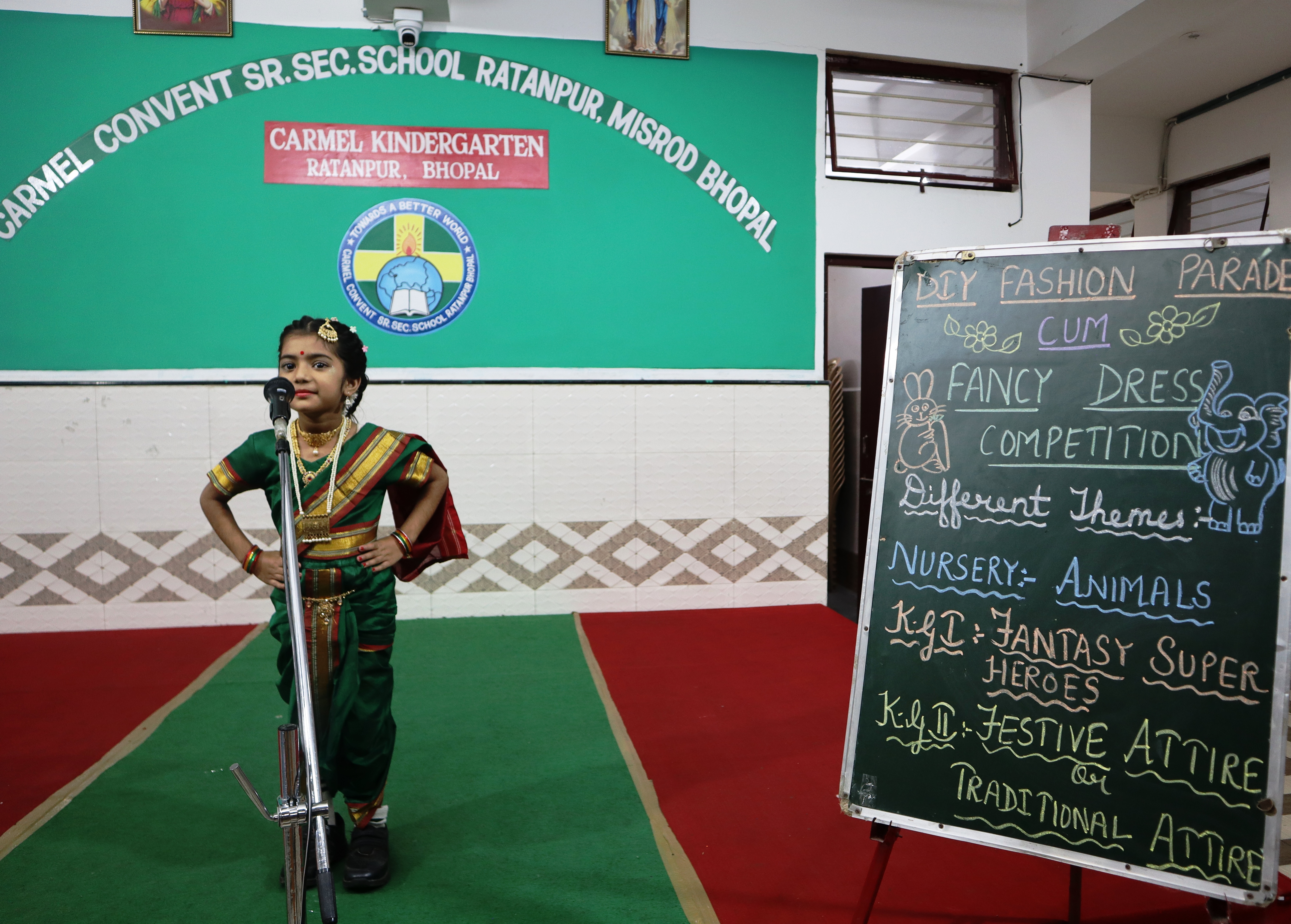 A child in traditional attire on stage during the fancy dress competition